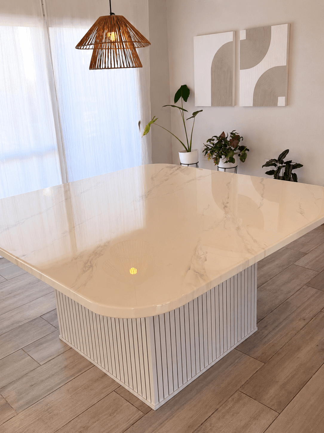 Mesa de porcelanato claro con base ranurada en un comedor luminoso